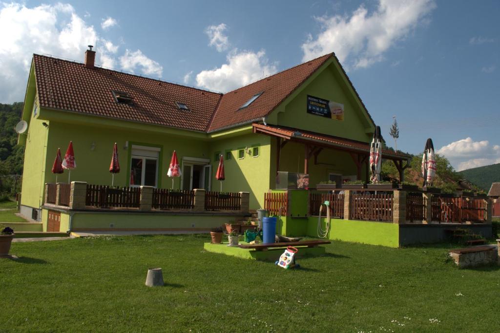 uma casa amarela com um quintal em frente em Ubytovanie Škulec em Stará Turá