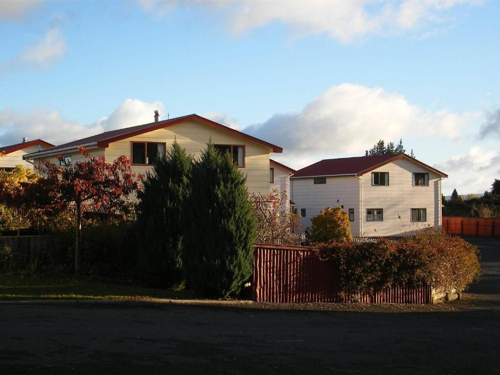 a white house with a fence in front of it at Ossies Motels and Chalets in Ohakune