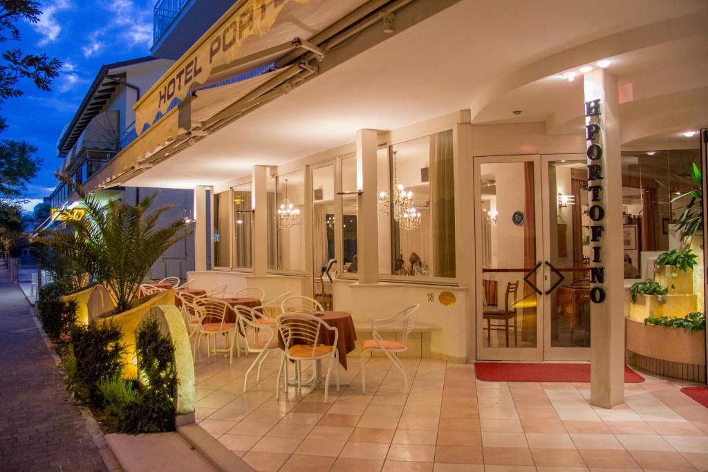 ein Restaurant mit Tischen und Stühlen außerhalb eines Gebäudes in der Unterkunft Casa Portofino Rooms&Breakfast in Cesenatico