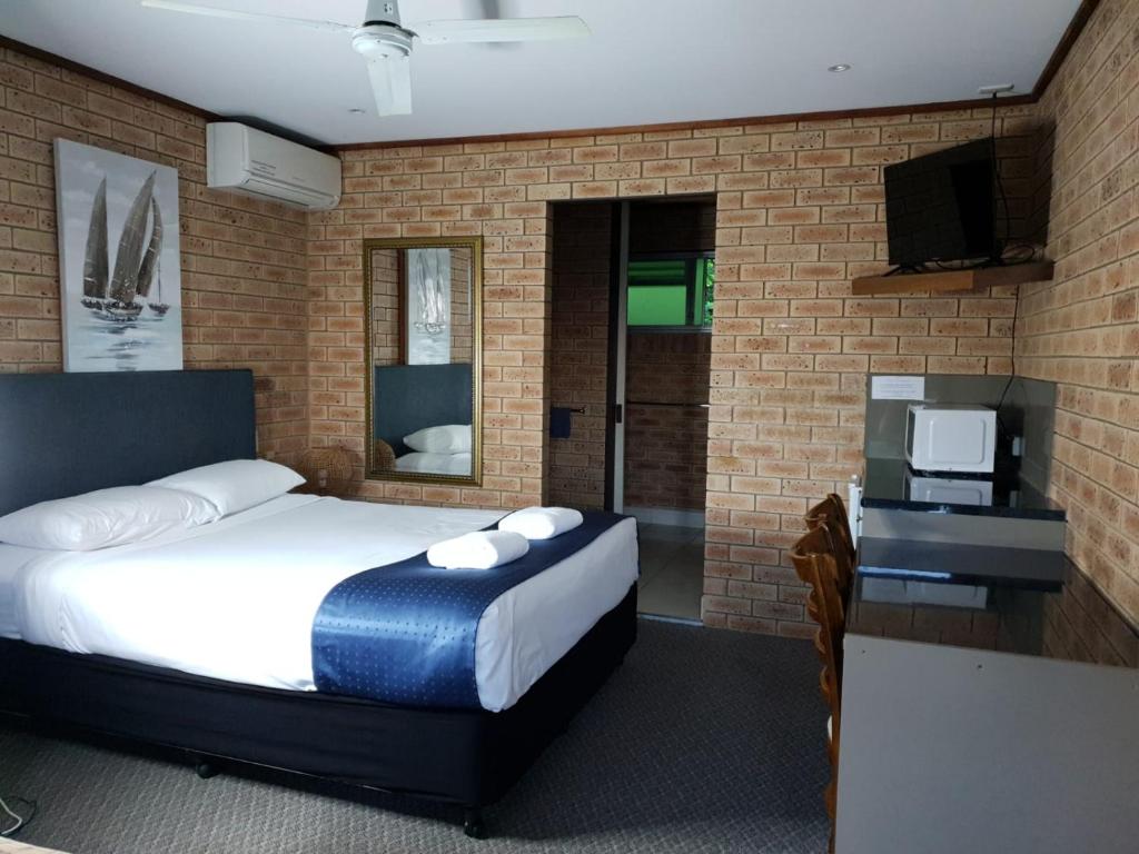 a hotel room with a bed and a television at Pacific Paradise Airport Motel in Pacific Paradise 