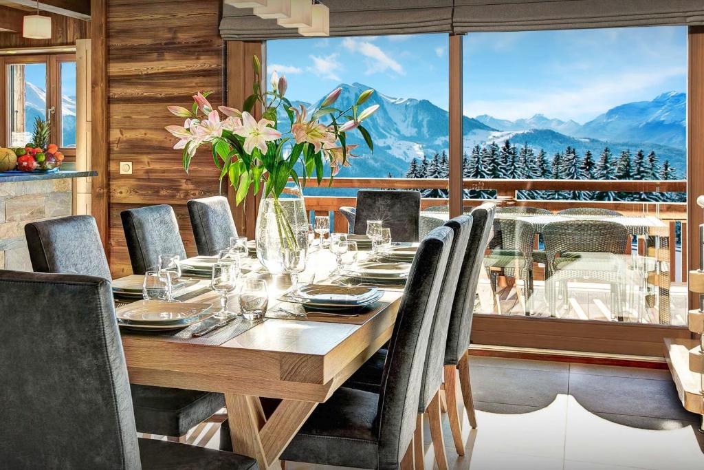 a dining room with a table and a view of mountains at Pralor Le Nova - OVO Network in Manigod