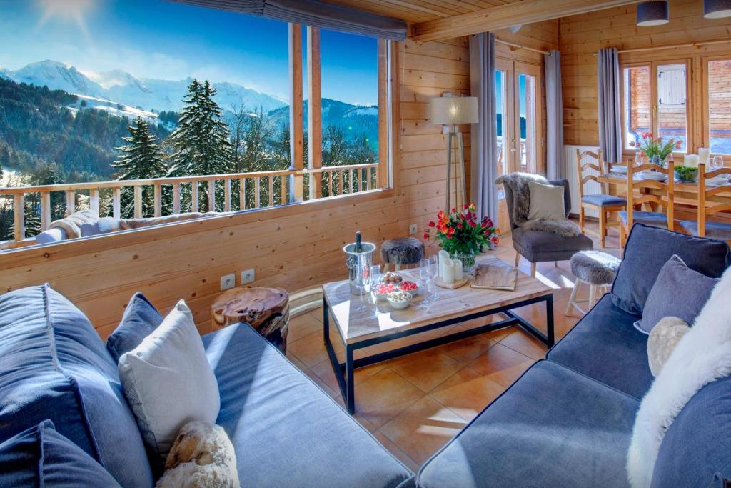 a living room with a couch and a table at Chalet des Mômes - OVO Network in Le Grand-Bornand