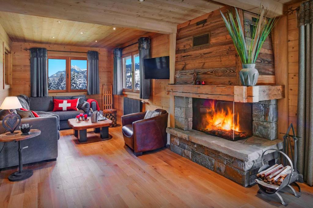 a living room with a fireplace in a cabin at Cristal des Neiges La Clusaz - OVO Network in La Clusaz