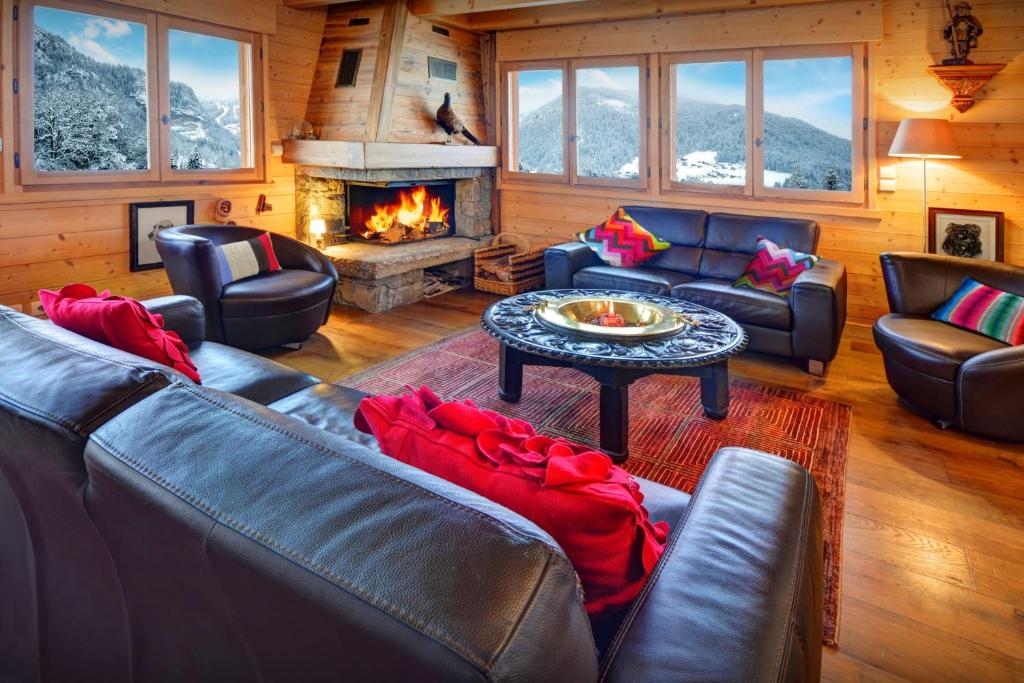 a living room with leather furniture and a fireplace at Chalet Polanka - OVO Network in Saint-Jean-de-Sixt