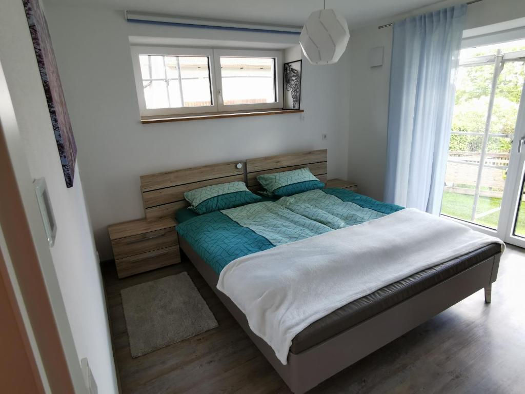 una camera da letto con un letto grande con una finestra di Ferienwohnung MIA-LENA a Penzing