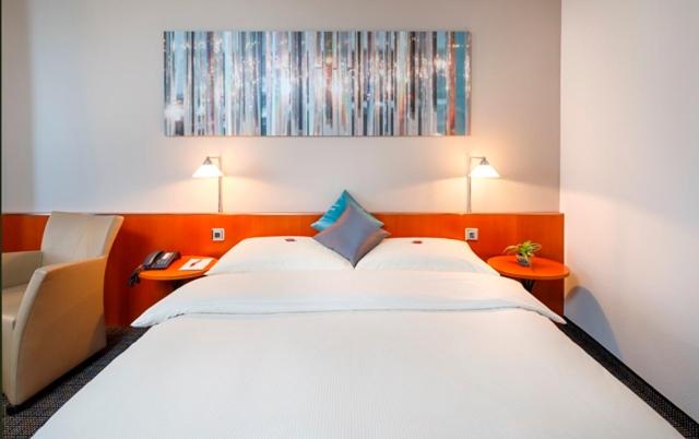 Postel nebo postele na pokoji v ubytování Hotel Metropol Basel