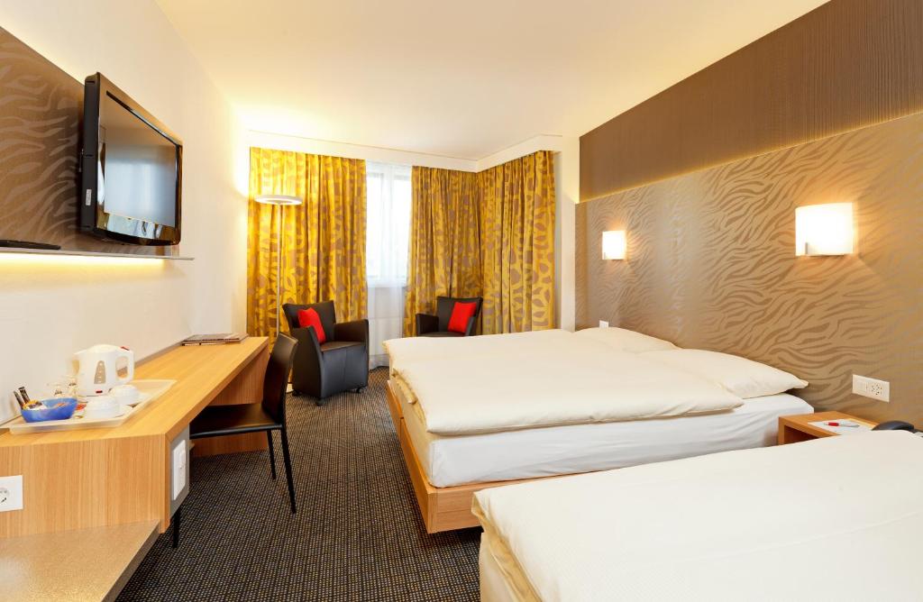 Postel nebo postele na pokoji v ubytování Hotel Metropol Basel