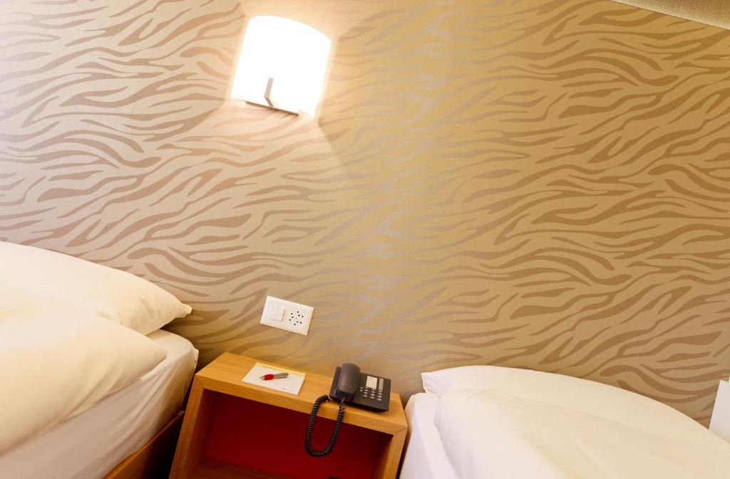 Postel nebo postele na pokoji v ubytování Hotel Metropol Basel