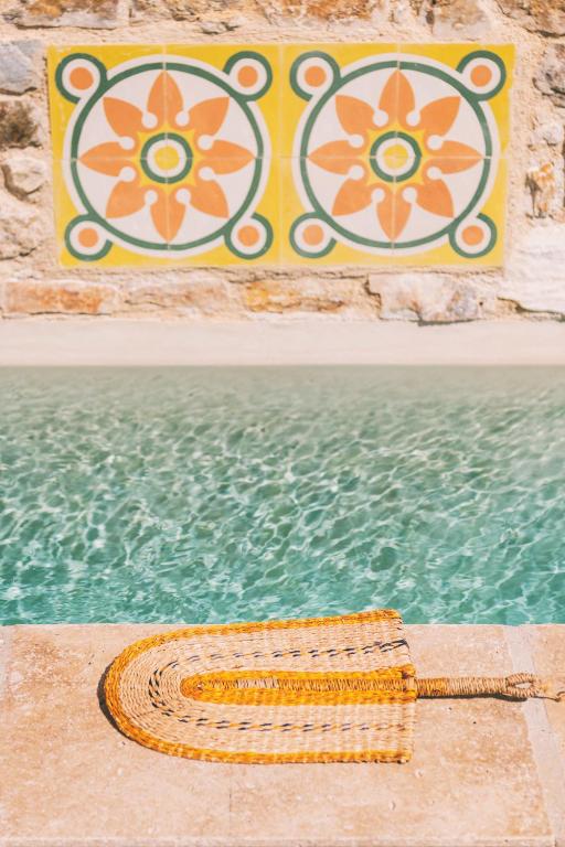 a wicker basket sitting next to a swimming pool at Aristide Hotel - Small Luxury Hotels of the World in Ermoupoli