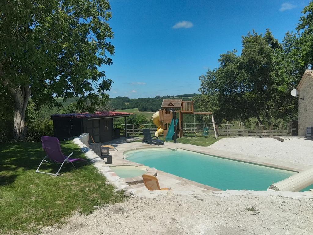 - une petite piscine dans une cour avec une aire de jeux dans l'établissement Gîte de caractère en pleine nature, à Bourg-de-Visa