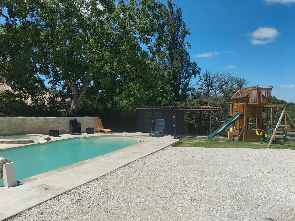 a swimming pool with a playground and a house at Gîte de caractère en pleine nature in Bourg-de-Visa