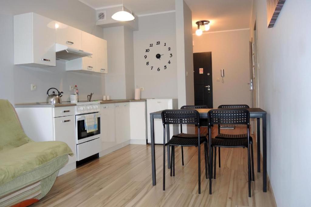 Apartament Centrum Wągrowiec في واغروويك: مطبخ مع طاولة وكراسي في غرفة