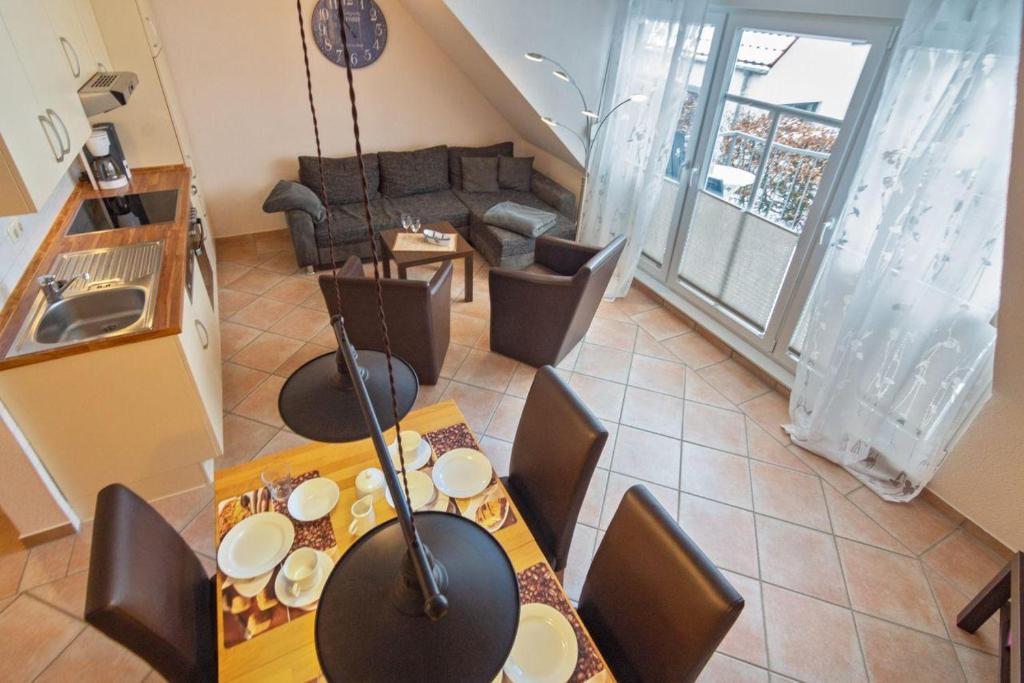 een woonkamer met een tafel en stoelen en een bank bij Ferienwohnung-achtern-Deich in Norddeich