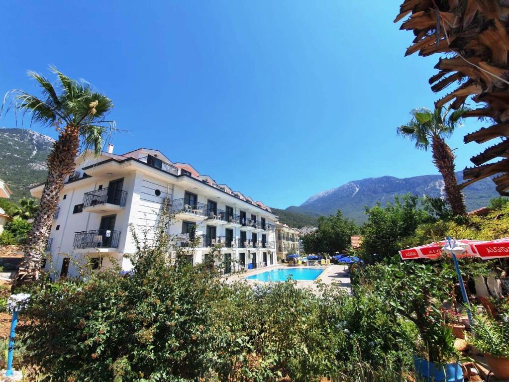 un hôtel avec une piscine et des palmiers dans l'établissement Milkyway Apart & Hotels, à Ölüdeniz