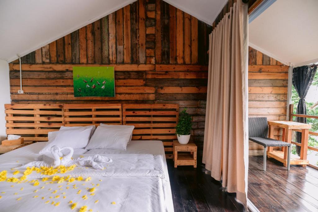 サバンにあるBeu Ceubeh Cottage Sabangの木製の壁のベッドルーム1室(ベッド1台付)