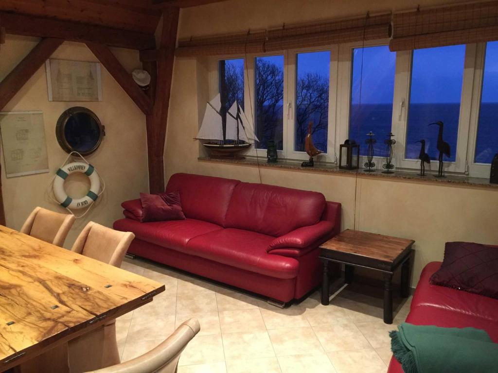 a living room with a red couch and a table at Seelotsenstation Turmwohnung Adler in Sassnitz