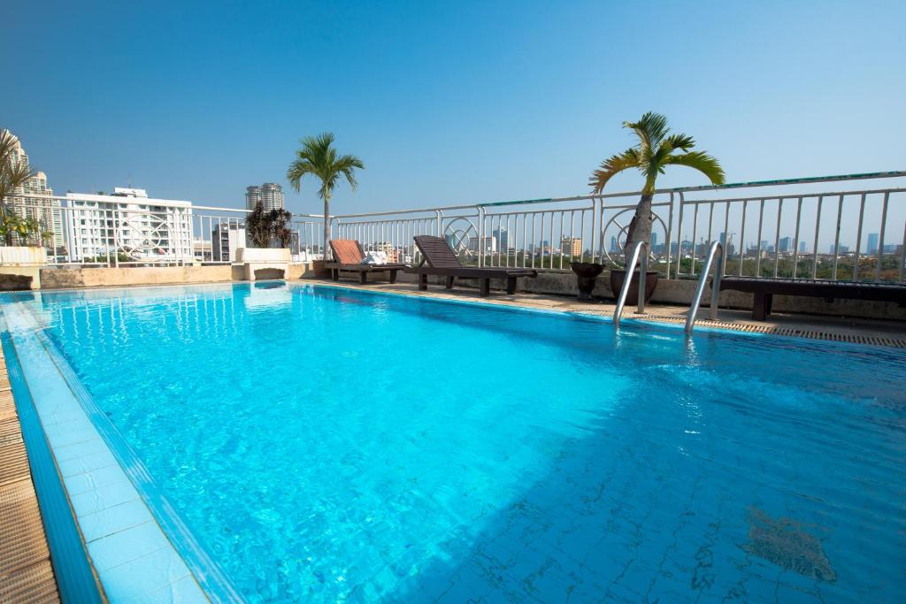 曼谷的住宿－聖景服務公寓酒店，一座大型蓝色游泳池,位于一座建筑的顶部