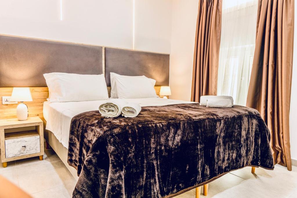 um quarto com uma cama grande com dois sapatos em The Mike Hotel by CX Collection em Cospicua