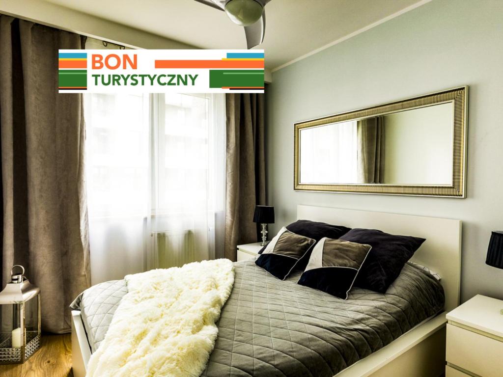 1 dormitorio con 1 cama y un letrero que lee bon tummyarchy en Jack II Apartment, en Cracovia