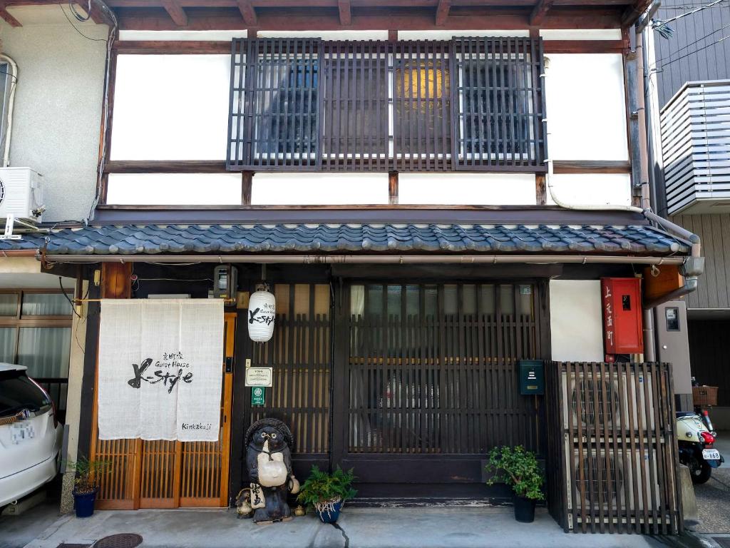 a building with an entrance with a gate and a building with aigunigunigun at K-style kinkakuji in Kyoto