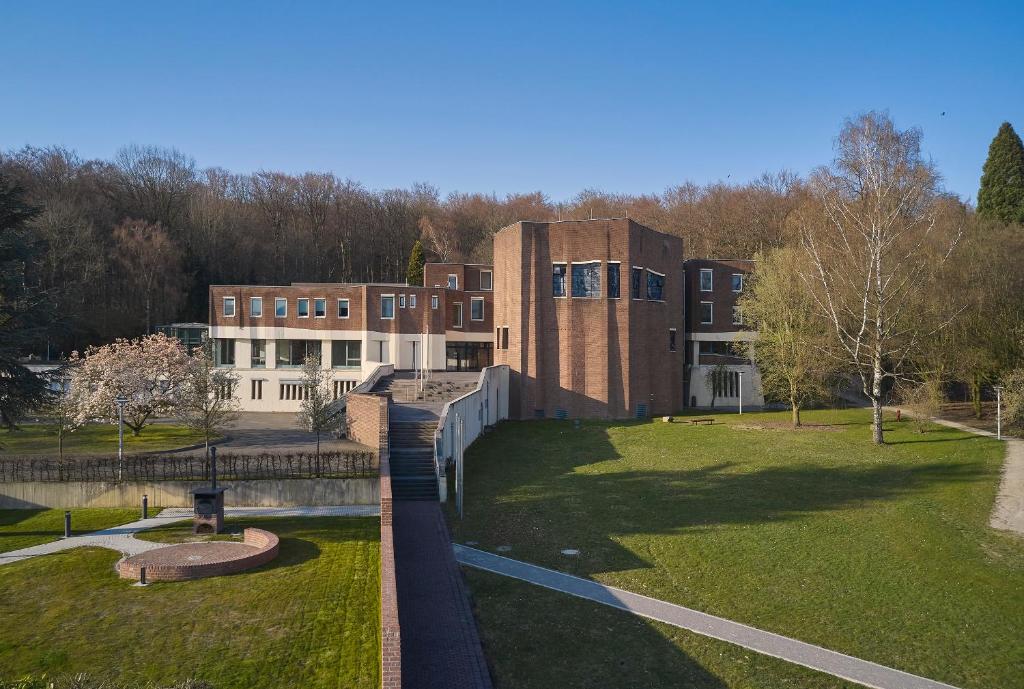 un grand bâtiment en briques avec un parc en face dans l'établissement Katholische Akademie Schwerte, à Schwerte