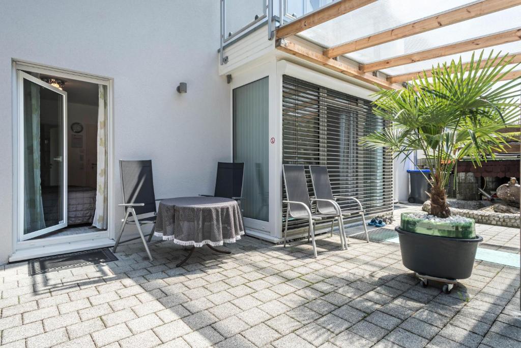 een patio met een tafel en stoelen bij Apartment mit Kaffeeküche für Zwei in Meersburg