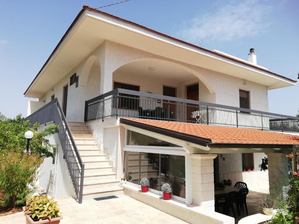 Casa blanca con balcón y escaleras en CASA DORI, en Cisternino