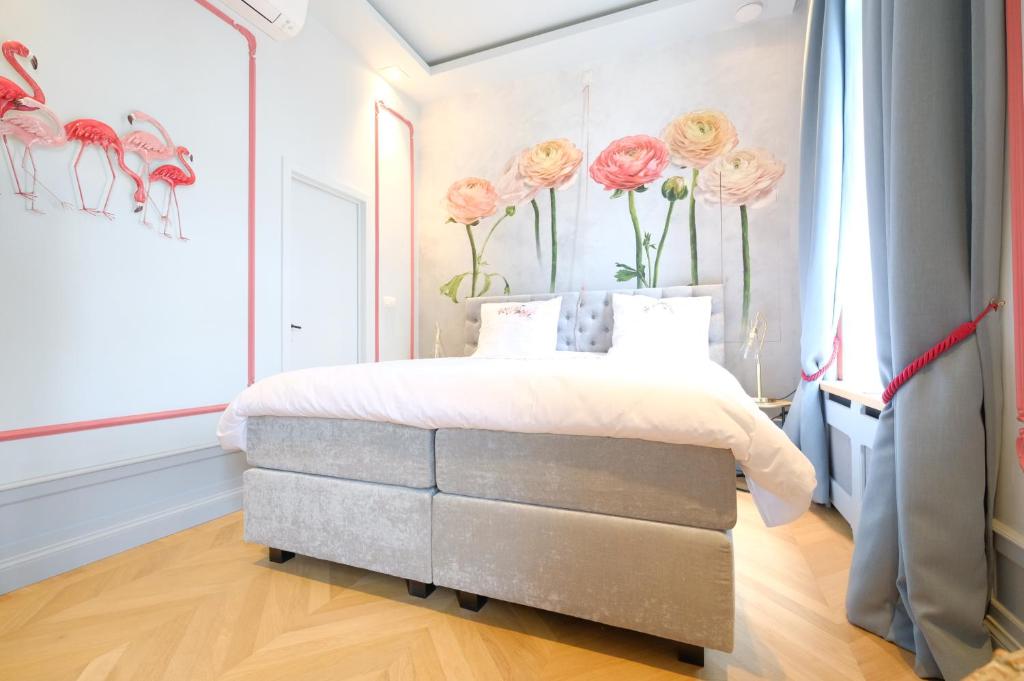 a bedroom with a bed with pink roses on the wall at La Maison de la Duchesse de la Vallière - Chambre Rosaline - Parking privé gratuit in Mons