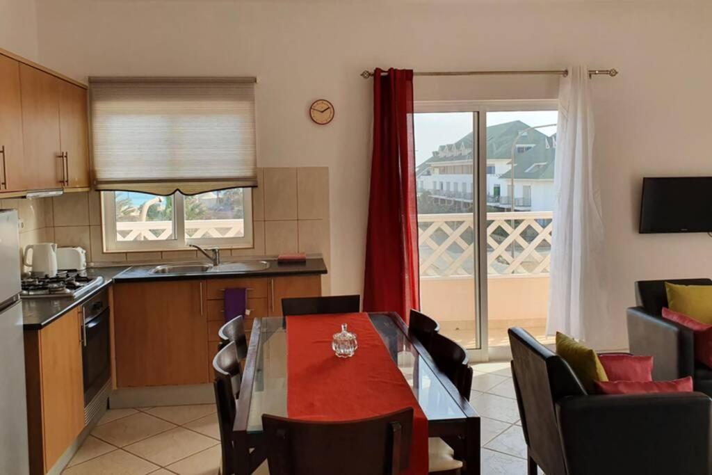 a kitchen with a table and chairs and a kitchen with a window at Santana double bedroom serviced apartment in Santa Maria