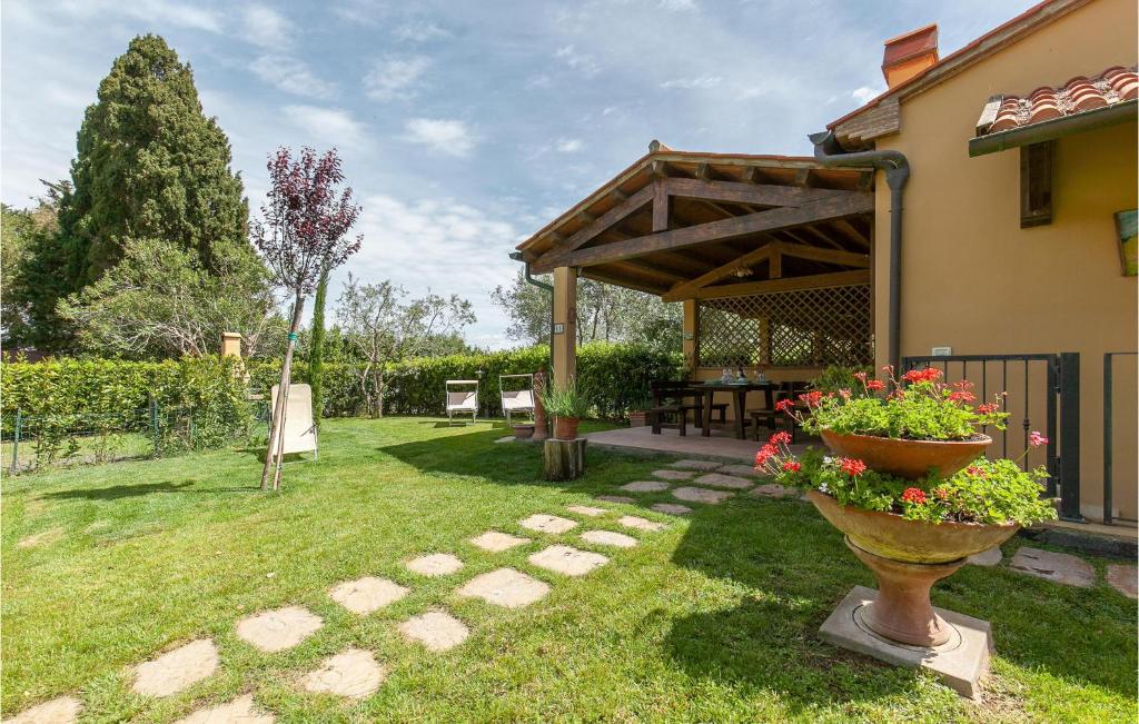 un giardino con patio, tavolo e fiori di Paradiso a Marina di Cecina
