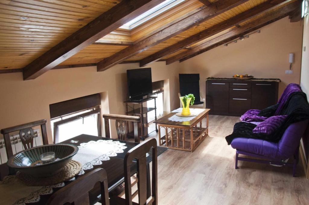 salon z fioletową kanapą i stołem w obiekcie La casa del rebote w mieście Acedo