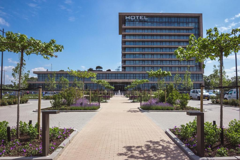 une passerelle devant un hôtel avec un bâtiment dans l'établissement Van der Valk Hotel Deventer, à Deventer