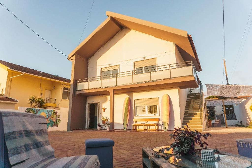 ein Haus mit einem Balkon und einer Terrasse in der Unterkunft Hospedium Hostel República Surf House in Ericeira