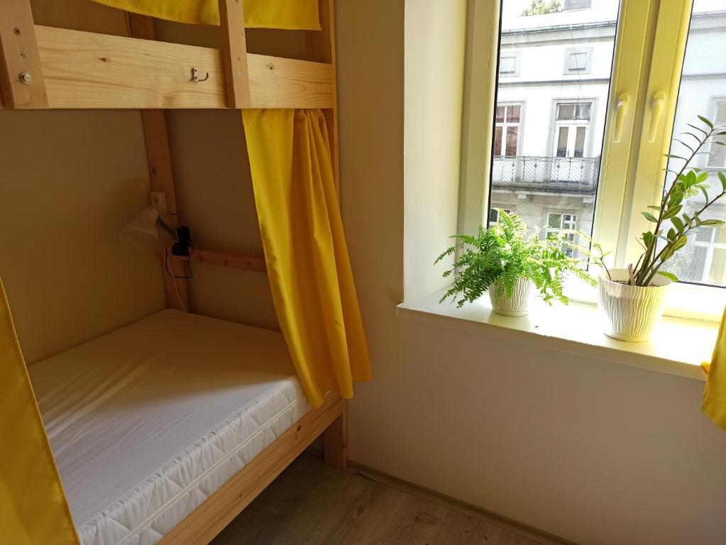 a small room with a bed and a window at Evergreen Hostel Krakow in Kraków