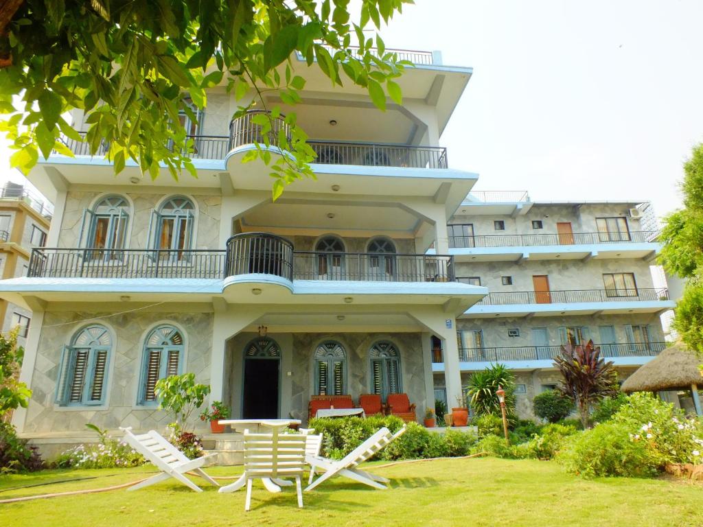 a building with two lawn chairs in front of it at Hotel Greenland in Pokhara