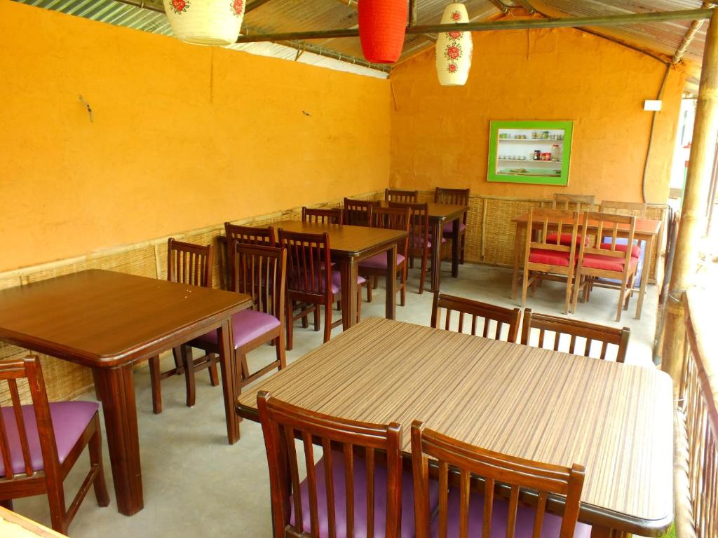 Un comedor con mesas y sillas de madera. en Hotel Greenland, en Pokhara