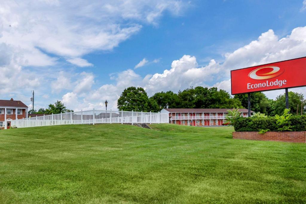 a building with a sign in front of a field at Econo Lodge Woodstock - Shenandoah Valley I-81 in Woodstock