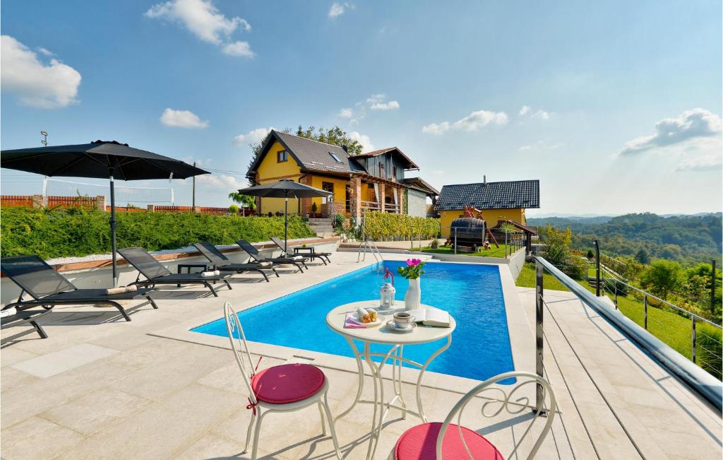 una piscina con sillas y una mesa junto a una casa en Beautiful Home In Cestica With Jacuzzi, en Cestica