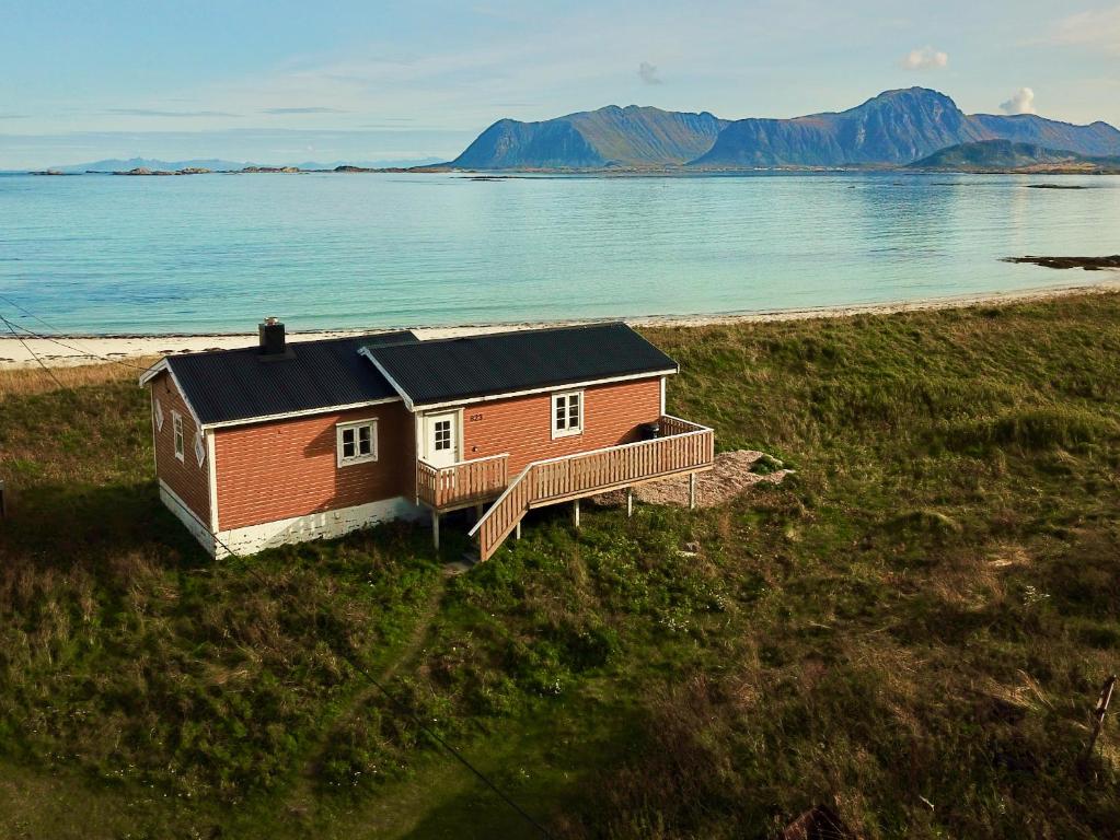 ein kleines Haus am Strand mit dem Wasser in der Unterkunft Seaside View Lofoten in Bøstad