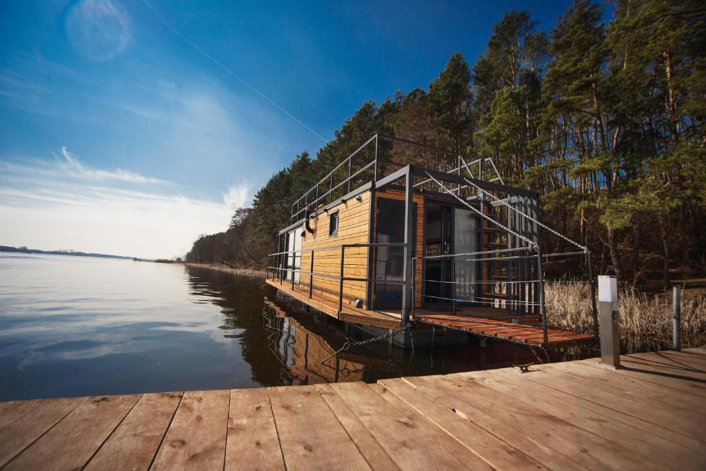 a house on a dock on a body of water at Nad Narvią in Serock