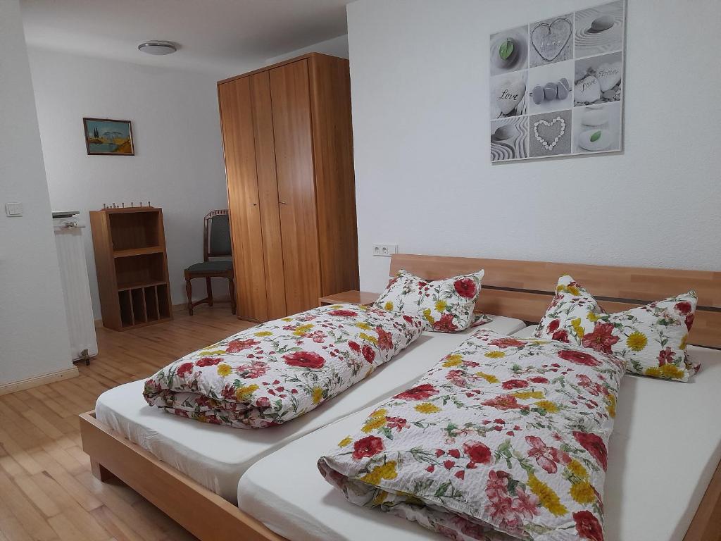 1 dormitorio con 2 camas y almohadas florales en Haus an der Leukquelle, en Perl