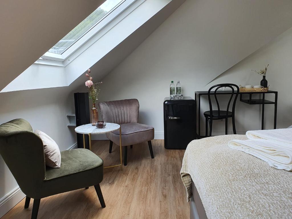 Habitación en el ático con cama, silla y mesa. en Boutique Hotel Villa Horbach en Idar-Oberstein