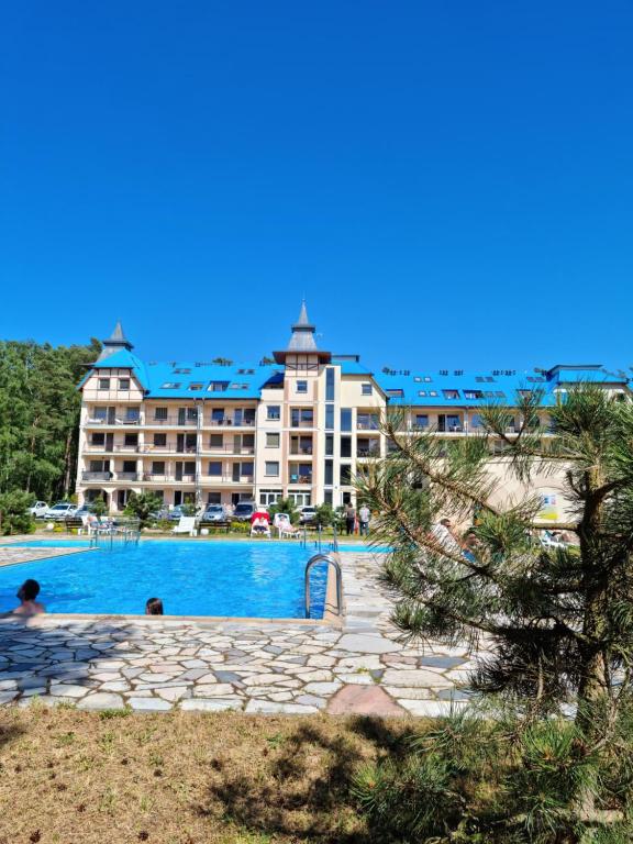 a hotel with a swimming pool in front of a building at BLUE MARE Apartamenty MES in Łukęcin