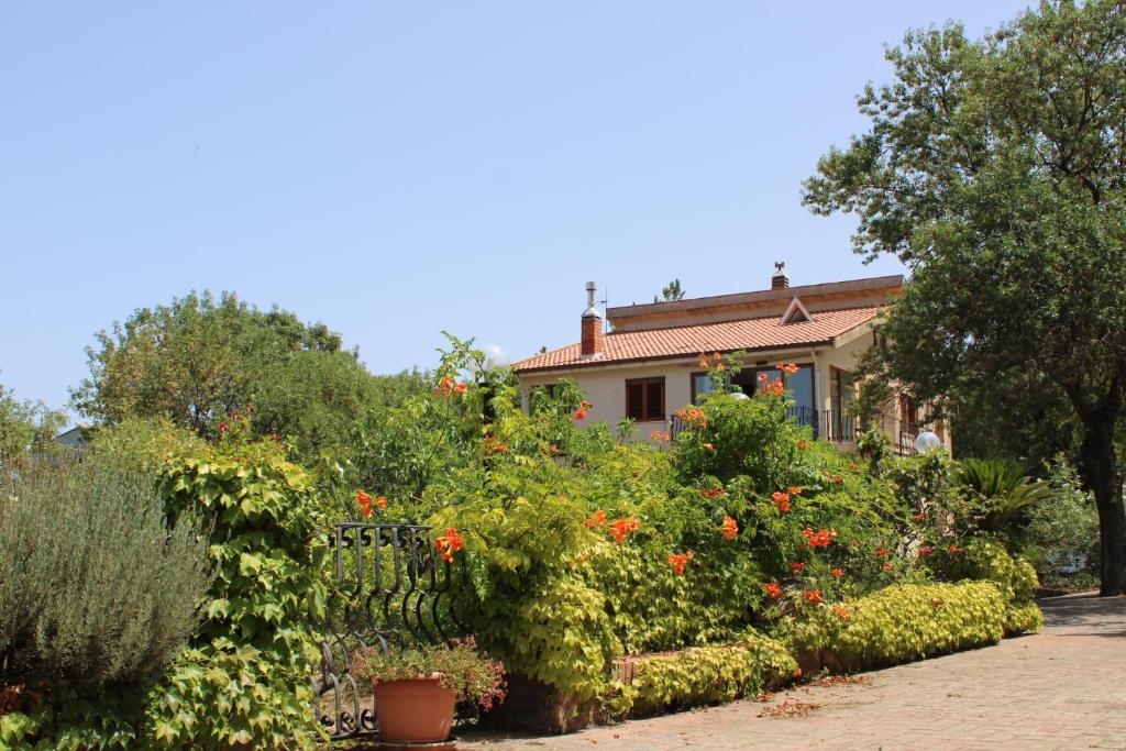 a house with a garden of flowers and plants at Villa Failla in Castelbuono