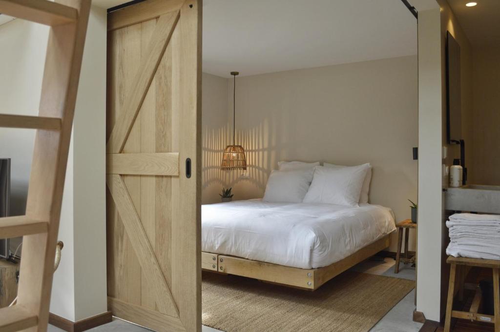 een slaapkamer met een bed en een schuifdeur bij Van Heeckeren Apartments & Suites Buren in Buren