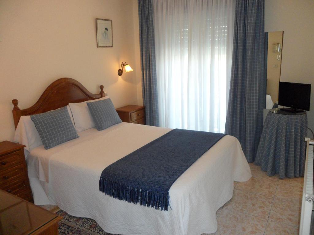 um quarto com uma cama grande e uma janela em Hotel Avenida em Sabaris