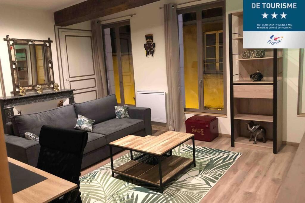 sala de estar con sofá y mesa de centro en Laon : Suite privée au pied de la cathédrale, en Laon