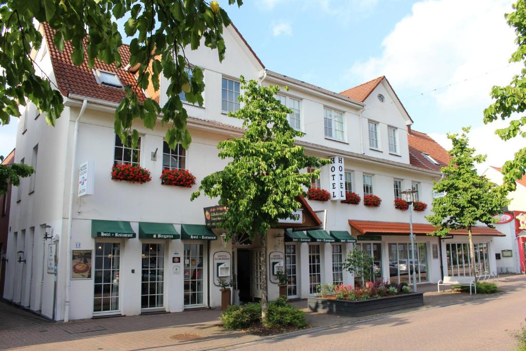 a white building with flowers on the windows at Hotel Schlömer in Cloppenburg
