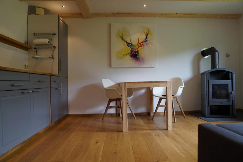 a kitchen with a table and chairs and a stove at Ruhiges Ferienhaus am Waldrand mit Sauna und Kamin in Langenbach