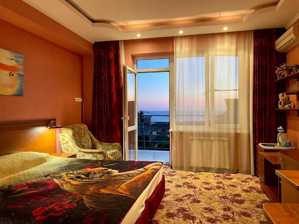 Habitación de hotel con cama y puerta corredera de cristal en Ledis Guest House en Sochi
